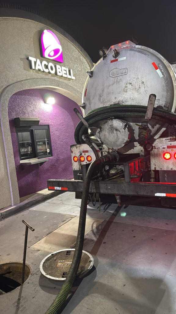 used cooking oil disposal truck outside restaurant during oil pickup and recycling service