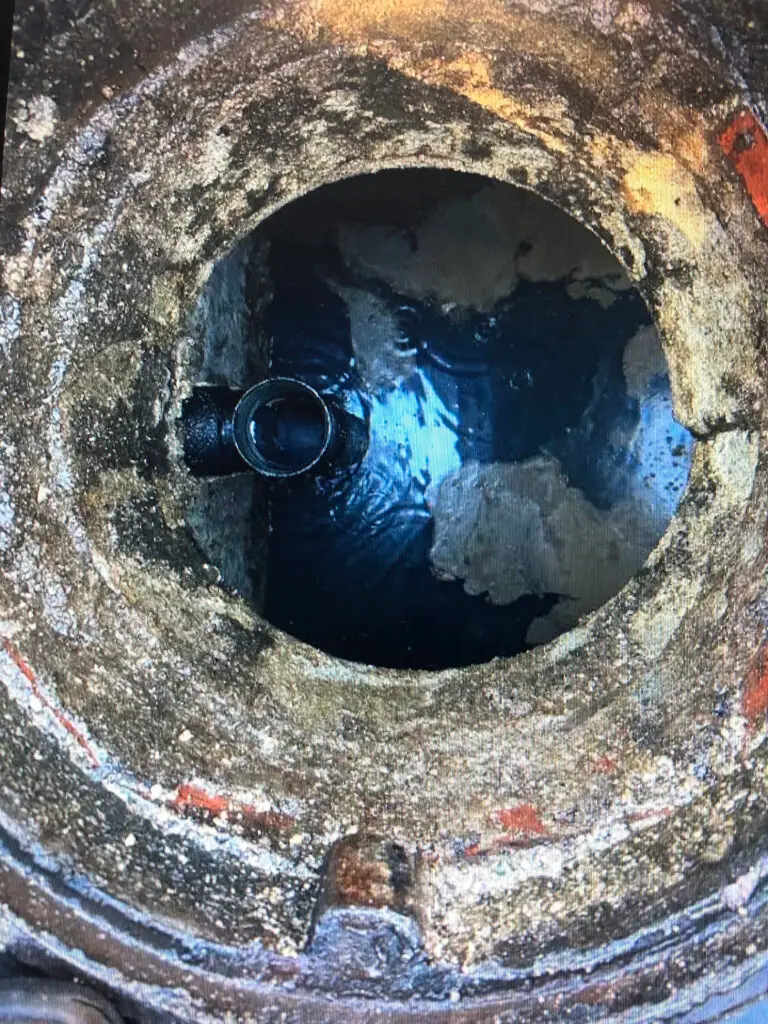 technician performing grease interceptor baffle T repair inside restaurant in Los Angeles