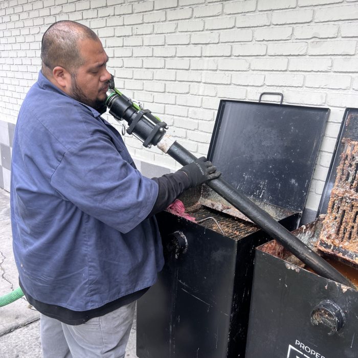 A technician from The Grease Company doing grease trap repair to ensure proper function.